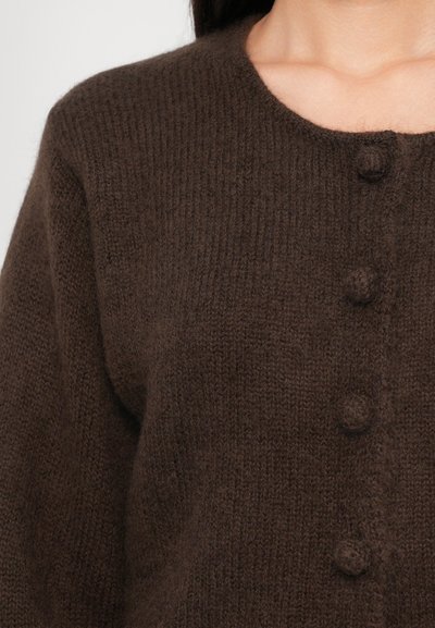 Brown knitted cardigan made from soft, textured material. Features a rounded neckline and four matching fabric-covered buttons.