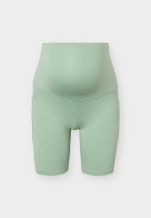 Hellgrüne Schwangerschafts-Biker-Shorts mit hohem, stützendem Bund, der für einen Babybauch konzipiert ist.