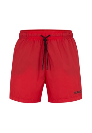 Pantaloni da bagno rossi realizzati in materiale leggero, con una cintura elastica e un cordino nero, e il logo "HUGO" in nero sul lato.