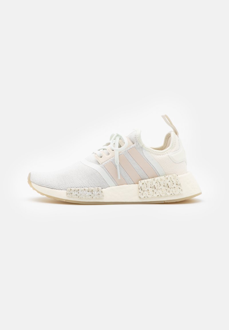 Baskets blanches de sport avec des rayures pastel roses et bleues, tige en mesh, semelle texturée et semelle intermédiaire mouchetée. Équipées d'une languette arrière.