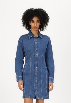 Denim shirt dress with long sleeves, button-down front, structured silhouette, chest pockets, and contrasting stitching.