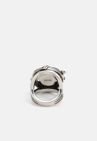 Anillo de plata con un diseño único y detalles intrincados, que presenta secciones suaves y texturizadas, y una inscripción de Versace en su interior.