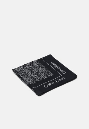 Écharpe noire Calvin Klein pliée, présentant un motif de logo CK blanc et le texte "Calvin Klein" sur les bords.