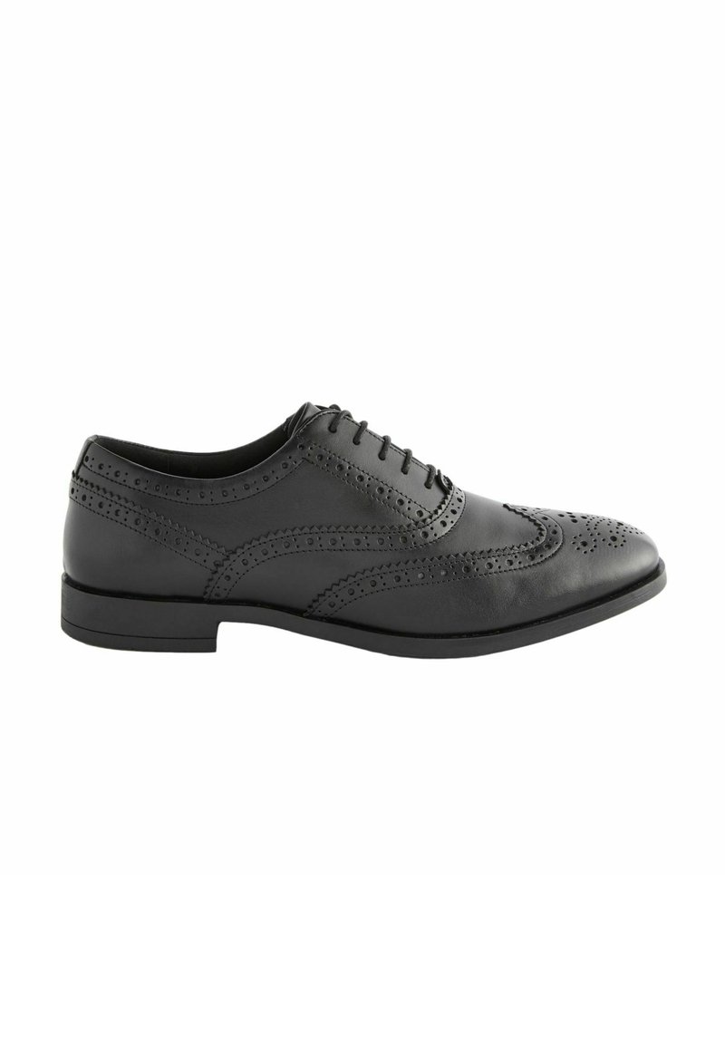 Zapato de vestir de cuero negro con perforaciones de brogue detalladas, punta redonda y un tacón bajo y apilado. Presenta un diseño de cordones y una textura suave.
