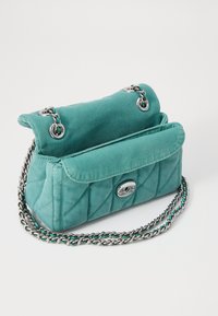 Teal quilted fabric handbag with a silver chain strap, fold-over flap, and snap closure. Features interior compartments for organization.