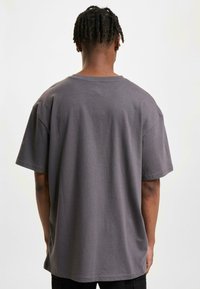 Gray cotton t-shirt with a relaxed fit, short sleeves, and a crew neck design, featuring a smooth texture and minimal detailing.