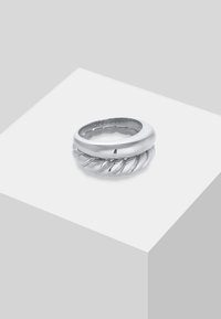 Anello in argento con una fascia liscia e curva e un elemento di design intrecciato, che mette in risalto una finitura lucida e dettagli testurizzati.
