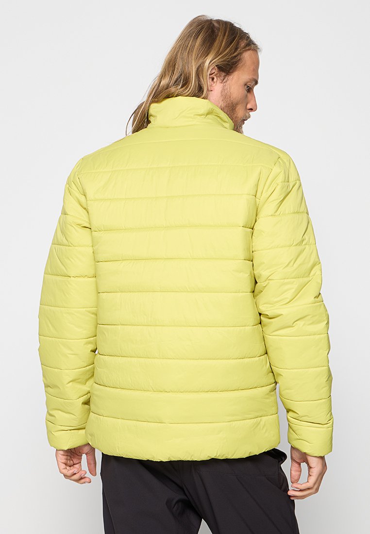 Chaqueta acolchada amarilla con costuras horizontales, cuello alto y textura suave, vista desde atrás. Diseño ligero e aislante.