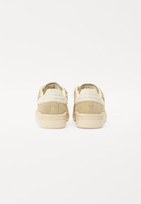 Suède en lederen sneakers in lichtbeige, met een ronde vorm, gevoerde kraag en een gestructureerde rubberen zool. Minimalistisch ontwerp zonder logo's.
