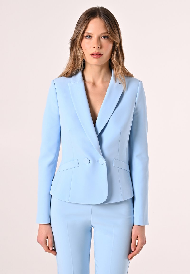 Light blue blazer with a tailored fit, notched lapels, two buttons, and side pockets, paired with matching pants. Smooth fabric texture.