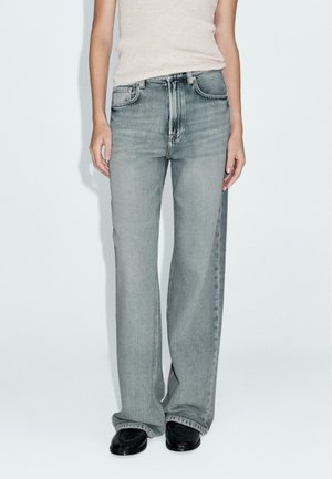 Light grey wide-leg jeans with a high waist and five pockets, made of denim, featuring subtle whiskering and a classic button closure.