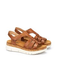 Sandalias de cuero marrón con múltiples correas, plantilla de corcho y suela de goma blanca, con un diseño de parte trasera abierta para facilitar su uso.