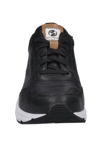Czarne skórzane buty sportowe z czarnymi sznurówkami, beżową metką na wyściełanym języku i białą gumową podeszwą o teksturowanym wzorze.