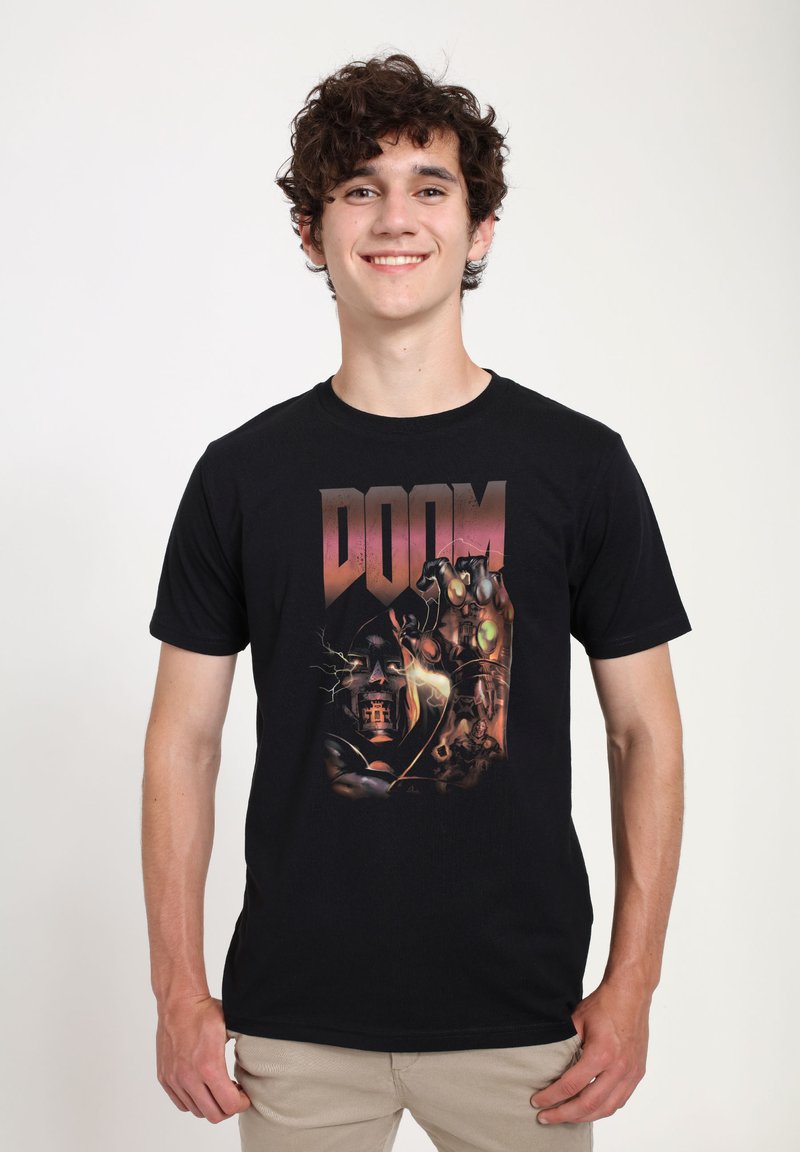 Černé bavlněné tričko s grafickým designem, na kterém je slovo "DOOM" tučnými, stylizovanými písmeny a složitými ilustracemi postav a prvků.