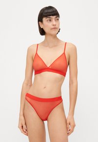 Rdeča prosojna bralette v trikotni obliki s tankimi naramnicami, v kombinaciji z ujemajočim prosojnim tangicami z enotnim pasom.