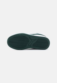 Semelle en caoutchouc verte avec un motif de semelle ondulée et un logo Puma. Présente une intermédiaire blanche et des accents vert foncé près du talon.