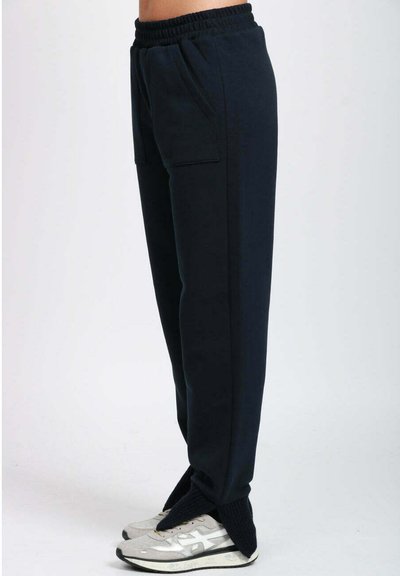 Pantaloni della tuta blu navy con elastico in vita, tasche laterali e vestibilità comoda. Realizzati in materiale morbido, caratterizzati da una texture liscia.