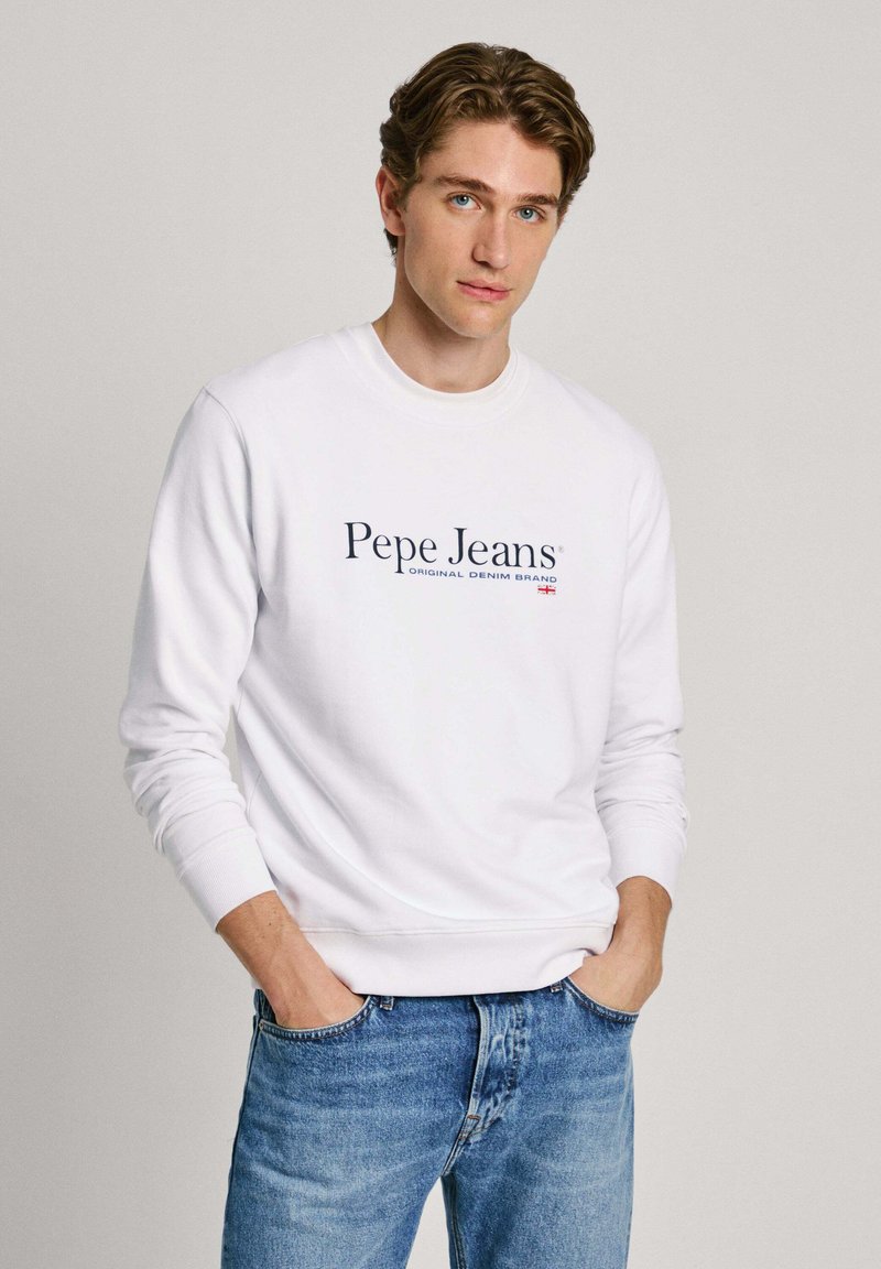 Sudadera blanca con cuello redondo, con el logo y texto en azul marino "Pepe Jeans" en el frontal, combinada con jeans de mezclilla azul claro.