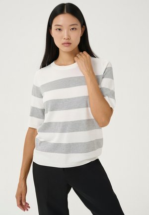 Pull à manches courtes rayé blanc et gris avec un col rond, une texture douce et une coupe décontractée, assorti à un pantalon noir.