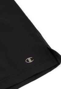 Schwarze Shorts aus glattem Material, mit einem dezenten grauen Logo in der Nähe des Saums. Das Design ist schlicht mit klaren Linien und ohne Muster.