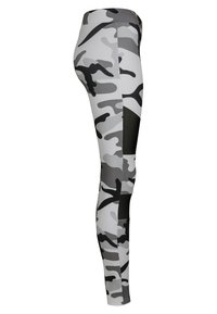 Høyt liv leggings i svart, hvit og grå kamuflasjemønster, med ensfargede svarte lapper på lårene.