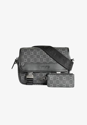 Sac bandoulière noir et gris avec un tissu à motifs, des accents en cuir, des accessoires en métal, une sangle ajustable et une petite pochette assortie.