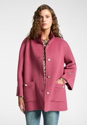 Cappotto in misto lana rosa con collo alto, chiusura a bottoni e due tasche frontali. Presenta bottoni in tonalità argento e maniche ampie.