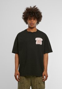 Sort oversized t-shirt lavet af bomuld. Har et grafik af en vintage telefon og teksten "Call My Lawyer" i rød på venstre brystområde.