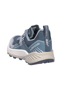 Scarpa da corsa blu e grigia con suola bianca spessa, linguetta posteriore e suola zigrinata, vista angolata che mostra il retro e il lato.