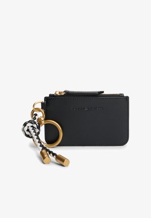 Porte-cartes en cuir noir avec ferrures dorées, fermeture éclair et porte-clés tressé avec des accents blancs et noirs. Texture lisse et design minimaliste.