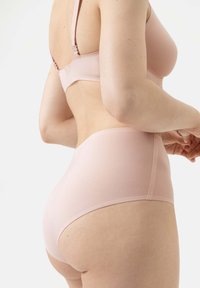 Hellrosa Lingerie-Set mit einem glatten, dehnbaren BH und hochgeschnittenen Panties mit nahtlosem Design und bequemem Sitz.