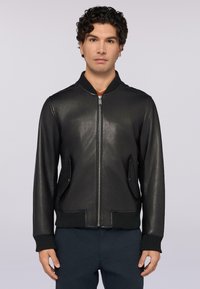 Chaqueta bomber de cuero negro con puños y dobladillo acanalados, cierre de cremallera en la parte delantera y dos bolsillos laterales, con una textura suave y un diseño sencillo.