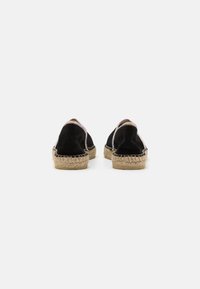 Espadrilles de ante negro con suelas de yute trenzado, presentando una textura suave y un patrón de costura claro a lo largo de los bordes y la parte trasera.