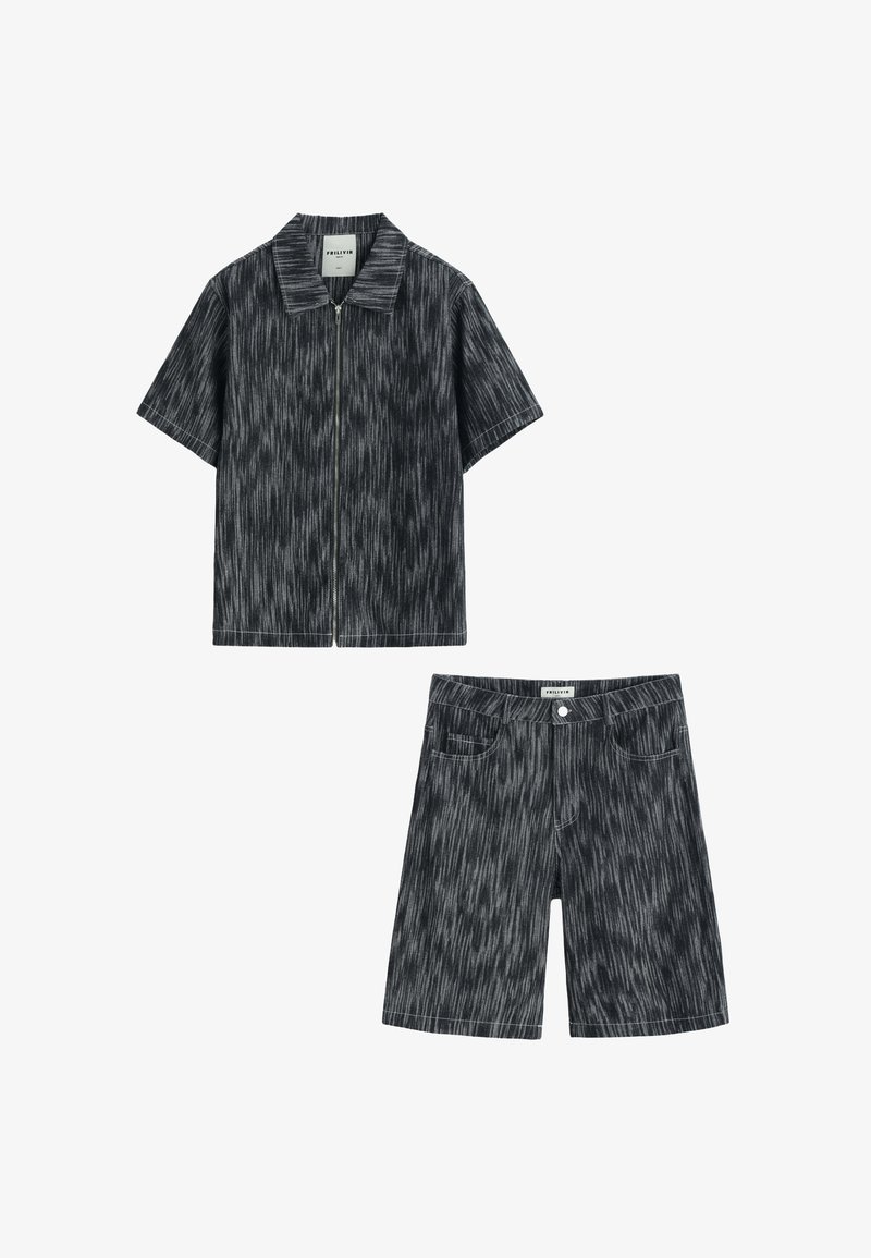 Chemise zippée à manches courtes et short longueur genou avec un motif rayé noir et blanc, tous deux provenant du même ensemble assorti.