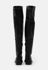 Botas de cuero negras hasta la rodilla con una textura suave, detalle de cordones en la parte superior y cremalleras laterales para facilitar su uso.