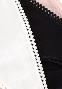 Confezione di tre slip con bordo in pizzo in bianco, nero e rosa. Materiale in cotone morbido con una texture liscia e bordi a ondina.