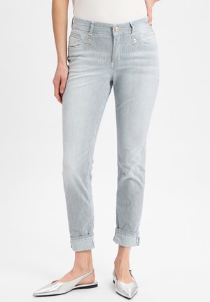 Gestreifte Denim-Hosen in Hellblau und Weiß, mit hoher Taille, aufgerolltem Saum und vorderen Taschen. Kombiniert mit silbernen Slingback-Schuhen.