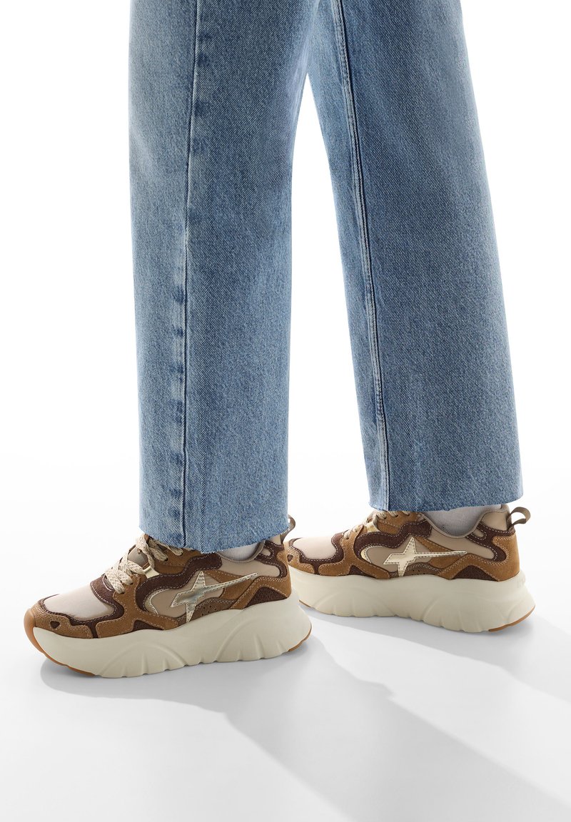 Sneaker marroni e beige con tomaia testurizzata, suola intermedia color crema e suola in gomma. Presentano accenti a contrasto e lacci rotondi.