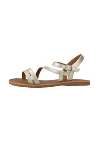 Metalen gouden sandalen met platte zolen, met gekruiste banden en een gespsluiting bij de enkel. Geëmailleerd leren bovenwerk en een gladde binnenzool.