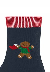 Granatowe skarpetki z prążkowanym czerwono-białym mankietem. Na nich wyszyty jest piernikowy ludzik w zielonym sweterku trzymający czerwone skarpety.