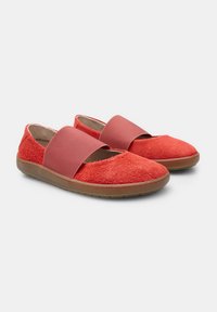 Zapatos de tela rojos sin cordones con una parte superior peluda, una amplia correa elástica en el empeine y una suela de goma. Diseño de puntera redonda y plana.