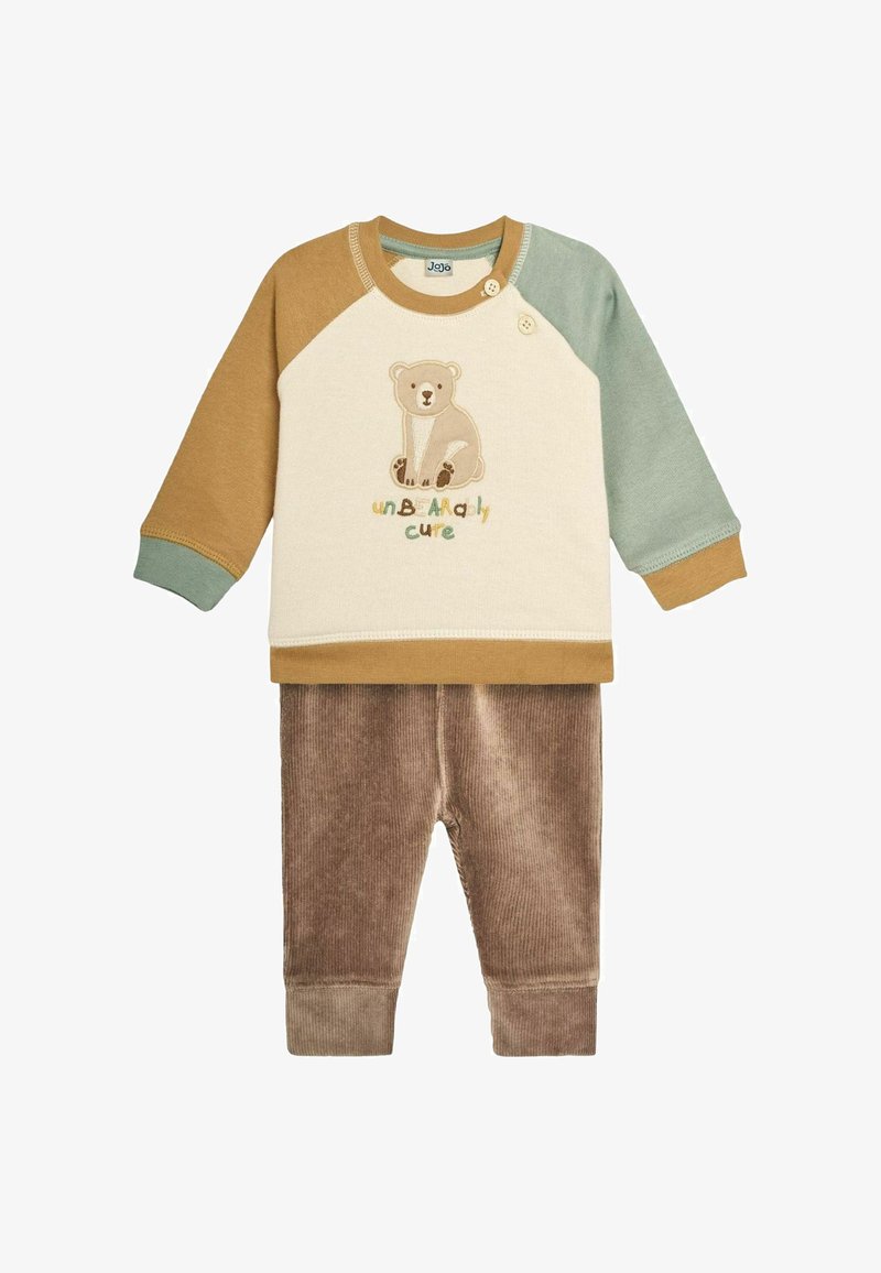 Bawełniany zestaw z kremową bluzką z nadrukiem misia oraz zielono-brązowymi rękawami, w połączeniu z brązowymi spodniami sztruksowymi. Guziki na ramieniu.