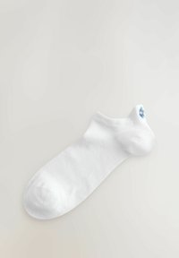 Vita ankelstrumpa i mjukt tyg, med rund tå och en liten blå blommig broderidetalj vid resåren.