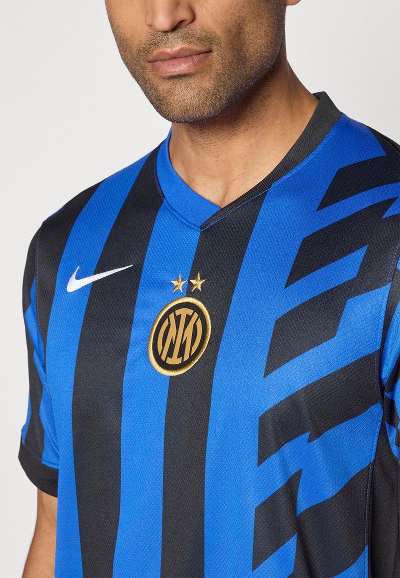 Hombre con camiseta de fútbol a rayas negras y azules del Inter de Milán, con el logo de Nike y dos estrellas doradas sobre el emblema del club.
