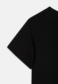 Černé bavlněné tričko s kulatým výstřihem a krátkým rukávem, hladkou texturou a jednoduchým designem. Končí u ramene.