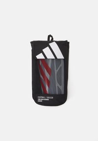 Zwarte scheenbeschermers tas met een transparante voorkant, waarin grijze en rode scheenbeschermers zichtbaar zijn. Kenmerkt zich door het Adidas-logo en een ophanglus.