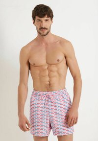 Herrenschwimmshorts in Hellrosa mit einem sich wiederholenden Muster aus kleinen blauen und rosa Autos. Verfügt über einen elastischen Bund mit Kordelzug.