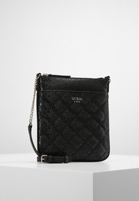 Černá prošívaná crossbody taška s embosovaným vzorem loga, zapínáním na zip a popruhem s řetízkem. Hladká textura a kompaktní obdélníkový tvar.