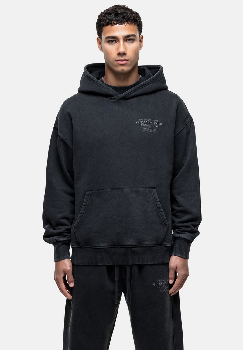 Felpa nera con cappuccio, tasca frontale, cordino e dettagli del logo sul petto. Realizzata in tessuto morbido e testurizzato. Vestibilità ampia.