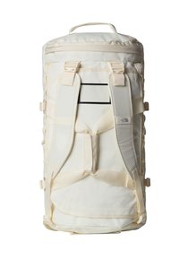 Cream-colored backpack with a cylindrical shape, padded straps, and multiple buckle closures. Features a textured patch for identification.